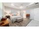 Light-filled main bedroom featuring a tray ceiling, a cozy rug, and an en-suite bathroom at 10033 Sw 96Th St, Ocala, FL 34481