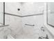 Modern shower with marble tile, grey accent stripe, grab bar, and glass enclosure showcasing a clean design at 10033 Sw 96Th St, Ocala, FL 34481