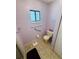 Well-lit bathroom with toilet, grab bar, and tiled floor at 10081 Sw 93Rd Ave, Ocala, FL 34481