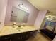 Traditional bathroom vanity with faux marble top and lighting fixture, adjoining bedroom with neutral carpet and bed at 10081 Sw 93Rd Ave, Ocala, FL 34481