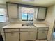 Functional kitchen area with double sink, white cabinets, and tile flooring at 10081 Sw 93Rd Ave, Ocala, FL 34481