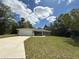 Charming single-story home featuring a lush lawn and a convenient attached two-car garage at 10785 Sw 130Th Ct, Dunnellon, FL 34432