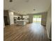 Open concept living room with wood flooring and a kitchen island, perfect for entertaining at 10785 Sw 130Th Ct, Dunnellon, FL 34432