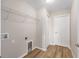 Functional laundry room with wooden floors, storage shelves, and utility connections at 10869 Sw 140Th Ave, Dunnellon, FL 34432