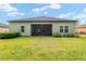 A view of the rear of a home with a screened lanai and spacious backyard at 1119 Se 42Nd Rd, Ocala, FL 34480