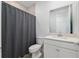 Bathroom with a gray shower curtain, toilet, and sink with a large mirror at 1119 Se 42Nd Rd, Ocala, FL 34480