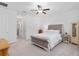 Bright bedroom with a tufted headboard bed, ceiling fan, and access to an en-suite bathroom for added convenience at 1119 Se 42Nd Rd, Ocala, FL 34480