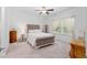 Cozy bedroom featuring a tufted headboard bed, soft carpet, and natural light from the window, creating a relaxing retreat at 1119 Se 42Nd Rd, Ocala, FL 34480