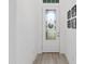 Clean and bright entryway with wood-look tile flooring, white walls, and decorative wall art at 1119 Se 42Nd Rd, Ocala, FL 34480