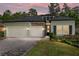 Charming single-Gathering home featuring a two-car garage, well-manicured lawn, and stone architectural details at 1119 Se 42Nd Rd, Ocala, FL 34480