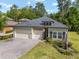 Charming home with a three-car garage, well-kept lawn, and attractive landscaping at 1119 Se 42Nd Rd, Ocala, FL 34480