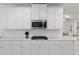 A modern kitchen featuring white cabinets, a stainless steel microwave, and a gas cooktop for gourmet cooking at 1119 Se 42Nd Rd, Ocala, FL 34480