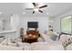 Cozy living room with a plush sofa, wooden coffee table, and a modern ceiling fan at 1119 Se 42Nd Rd, Ocala, FL 34480