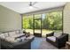 Enclosed porch featuring furniture and a view of the lush green yard at 1119 Se 42Nd Rd, Ocala, FL 34480