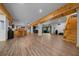Open basement layout with wooden ceiling beams, wood floors, and a bar seating area at 11311 Ne 40Th Street Rd, Silver Springs, FL 34488
