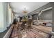 Stylish dining room with rustic table, chairs, and unique chandelier, open to living space at 11311 Ne 40Th Street Rd, Silver Springs, FL 34488