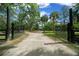 Long driveway leading to the home, framed by an ornate iron gate and lush greenery at 11311 Ne 40Th Street Rd, Silver Springs, FL 34488