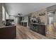Modern kitchen with sleek dark cabinetry, stainless steel appliances, and stone accent wall at 11311 Ne 40Th Street Rd, Silver Springs, FL 34488