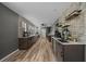 Long kitchen has sleek dark cabinetry, stainless steel appliances, and stone accent wall at 11311 Ne 40Th Street Rd, Silver Springs, FL 34488