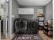 Well-equipped laundry room with modern washer and dryer, storage cabinets, and a functional layout at 11311 Ne 40Th Street Rd, Silver Springs, FL 34488