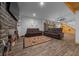Basement living room with a stone fireplace, hardwood floors, and comfortable seating with a rustic rug at 11311 Ne 40Th Street Rd, Silver Springs, FL 34488