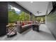 Relaxing screened porch featuring a comfortable couch, stylish tables, ceiling fan, and serene wooded views at 11311 Ne 40Th Street Rd, Silver Springs, FL 34488