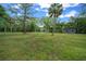 Lush green lawn with mature trees on a beautiful lot with a modern home in the background at 11311 Ne 40Th Street Rd, Silver Springs, FL 34488