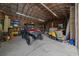 Well-lit shed interior with a red ATV, storage boxes, and a variety of tools and equipment at 11311 Ne 40Th Street Rd, Silver Springs, FL 34488