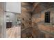 Custom walk-in shower with pebble floor, stone tile, and multiple shower heads at 11311 Ne 40Th Street Rd, Silver Springs, FL 34488