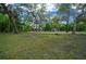 Sprawling lawn with mature trees and a glimpse of the home in the background at 11311 Ne 40Th Street Rd, Silver Springs, FL 34488
