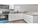 Modern kitchen features stainless steel stove and microwave, stone countertops, and white cabinetry at 11415 Nw 15Th St, Ocala, FL 34482