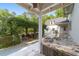 Stone outdoor kitchen with fire pit and seating area under a pergola offer an inviting outdoor space at 1251 Sw 43Rd Pl, Ocala, FL 34471