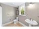 Neutral bathroom with pedestal sink, toilet, and natural light from window at 1251 Sw 43Rd Pl, Ocala, FL 34471
