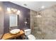 Modern bathroom with a stone vessel sink, tiled shower, and dark accent wall at 1251 Sw 43Rd Pl, Ocala, FL 34471