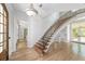 Spacious foyer featuring hardwood floors, a gracefully curved staircase, and elegant lighting at 1251 Sw 43Rd Pl, Ocala, FL 34471