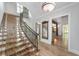 Grand foyer showcasing light wood floors, custom staircase, and decorative wrought iron railing at 1251 Sw 43Rd Pl, Ocala, FL 34471