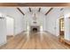 Bright living room with hardwood floors, exposed beams, a brick fireplace, and elegant chandelier at 1251 Sw 43Rd Pl, Ocala, FL 34471