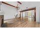 Open-concept living area with hardwood floors, exposed beams, brick fireplace, and access to other rooms at 1251 Sw 43Rd Pl, Ocala, FL 34471
