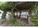 Outdoor dining area beneath a leafy pergola, creating an inviting space to enjoy the beautiful surroundings at 1251 Sw 43Rd Pl, Ocala, FL 34471
