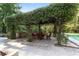 An outdoor dining area is featured beneath a pergola covered in lush greenery, offering a tranquil space at 1251 Sw 43Rd Pl, Ocala, FL 34471