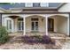 Close up of covered front porch featuring stone floor, white columns, and wooden doors at 1251 Sw 43Rd Pl, Ocala, FL 34471