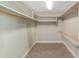 Neutral walk-in closet with built in shelving and wood rod for hanging clothing at 1251 Sw 43Rd Pl, Ocala, FL 34471