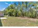 View of the expansive back yard with tree coverage, shed, and a cement patio at 13173 Sw 65Th Cir, Ocala, FL 34473