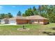 Single-story home exterior with a spacious lawn, two-car garage, and neatly landscaped yard at 13173 Sw 65Th Cir, Ocala, FL 34473