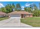 Charming single-story home features a two-car garage and well-maintained front yard with mature trees at 13173 Sw 65Th Cir, Ocala, FL 34473