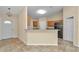 Open kitchen featuring tile floors, stainless steel refrigerator, breakfast bar, and bright lighting at 13173 Sw 65Th Cir, Ocala, FL 34473