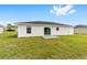 A beautiful backyard featuring a sliding glass door and a well-maintained lawn at 13333 Sw 113 Pl, Dunnellon, FL 34432