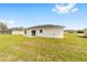 Home's backyard features a spacious lawn and patio space, perfect for outdoor activities at 13333 Sw 113 Pl, Dunnellon, FL 34432