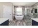 Bathroom featuring a modern soaking tub, a walk-in shower, and stylish walls and flooring at 14115 Nw 141St Ave, Williston, FL 32696