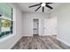 Spacious bedroom with wood-look floors, a large window, ceiling fan and a walk-in closet at 14115 Nw 141St Ave, Williston, FL 32696